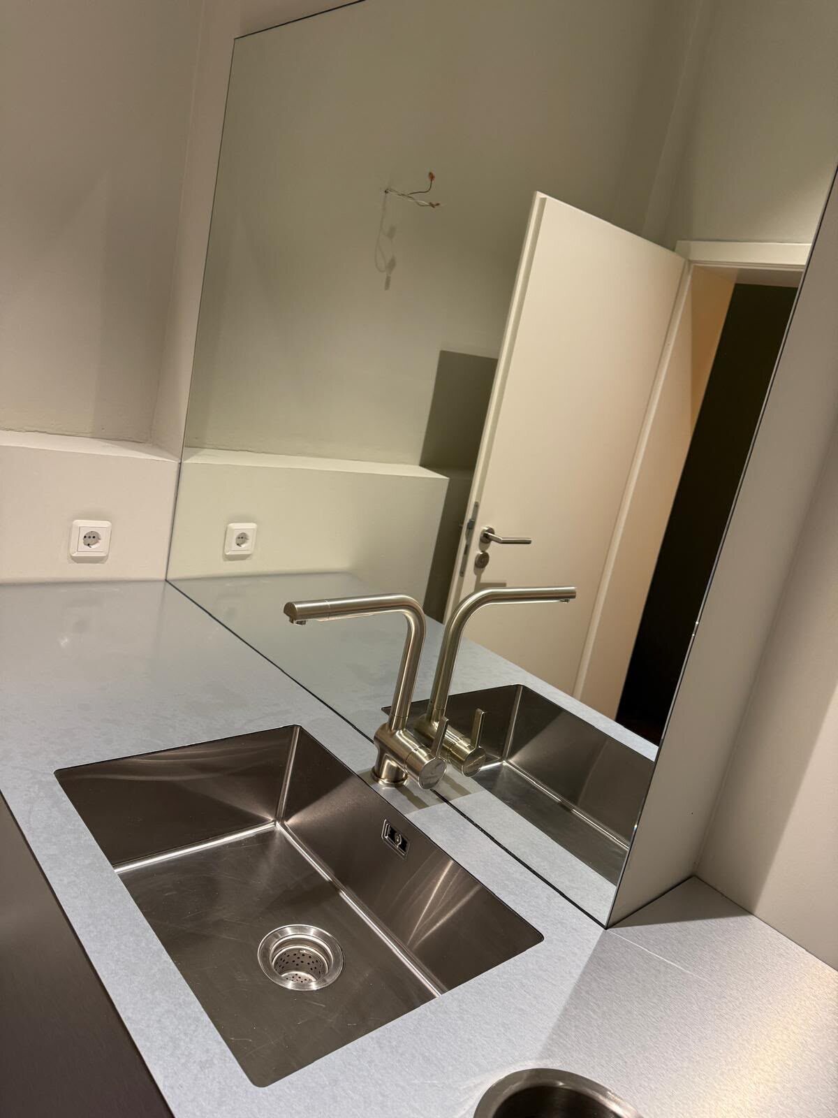 Waschplatz mit Edelstahlbecken und großem Spiegel ohne auffällige Spritzer