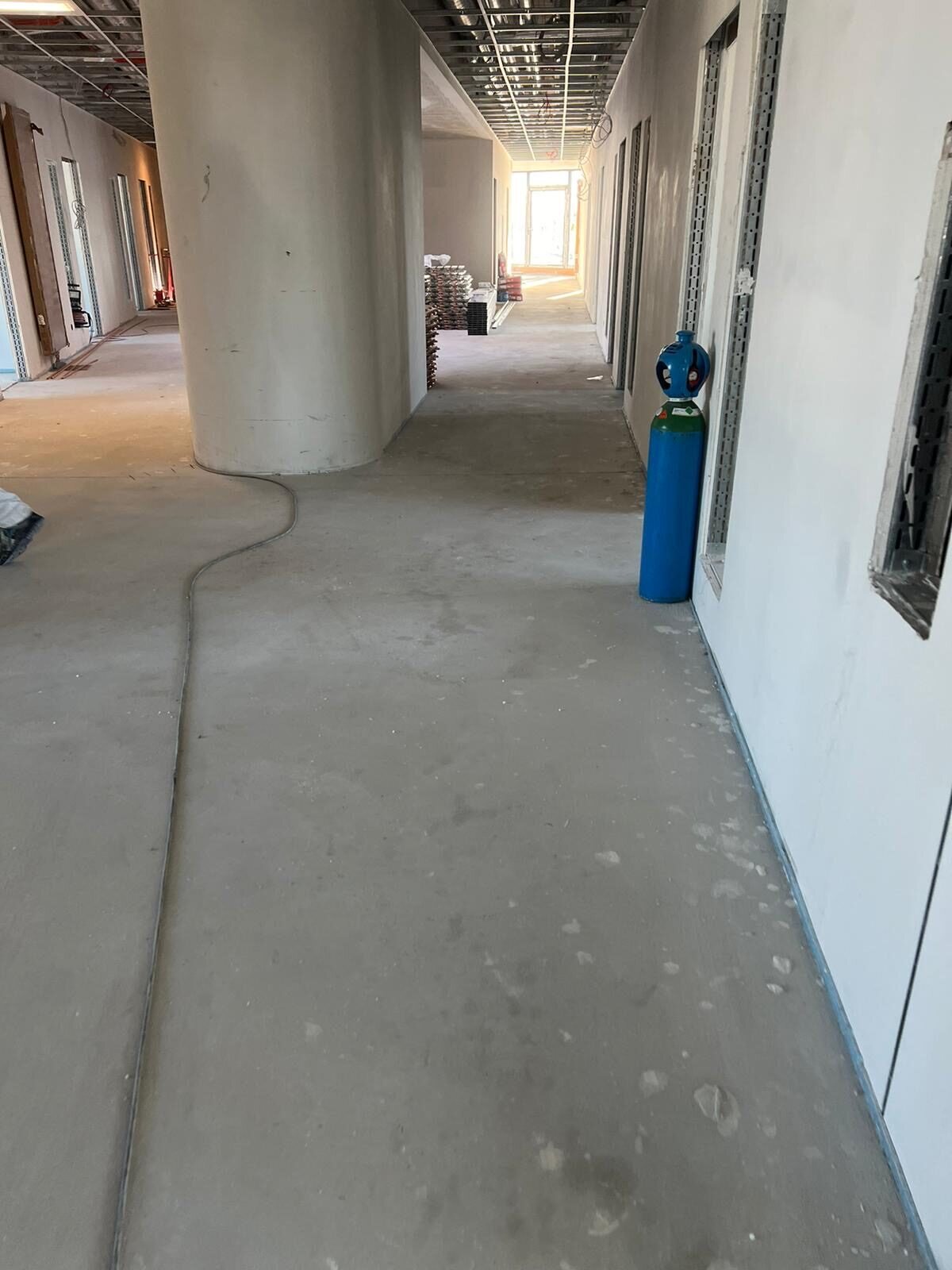 Flur im Ausbau mit offener Decke und verschmutztem Estrichboden