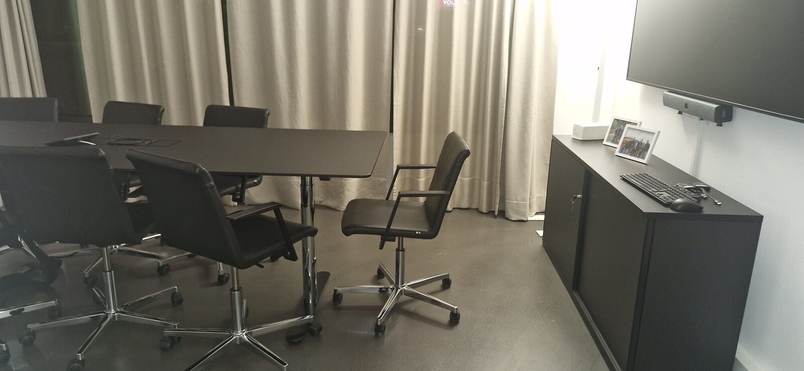 Besprechungsraum mit geordneten schwarzen Bürostühlen und freiem grauem Boden